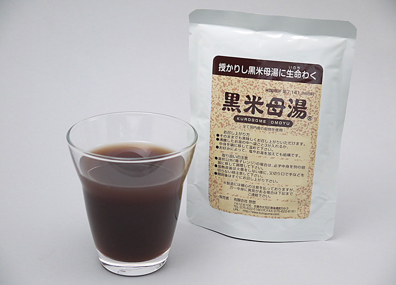 黒米母湯1袋130gをガラスカップに注いだ状態 茶紫色の半透明でさらりとした重湯 粘度低く粒なし 旧パッケージ